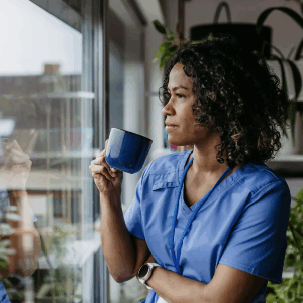 A woman drinking a coffee looking at a window