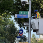 A NYC DOT worker installs a temporary street sign bearing Knicks championship team starter Josh Hart’s name and jersey number at the corner of Manhattan’s Sixth Avenue and 3rd Street.