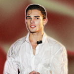 A man standing who is we4aring a white shirt