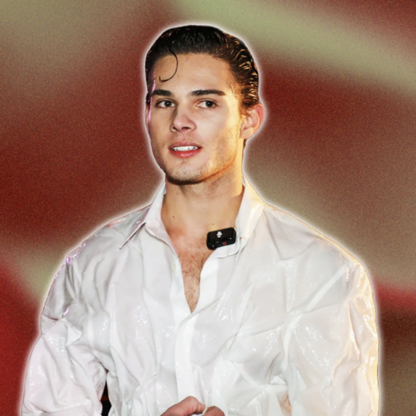 A man standing who is we4aring a white shirt